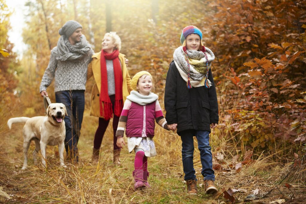 Parents with children walking in autumn woods