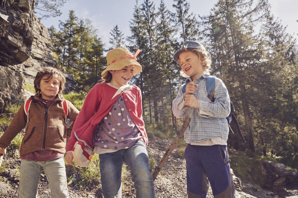 Three children exploring forest